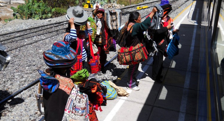 Vendendo artigos típicos enquanto o trem para em Ollantaytambo